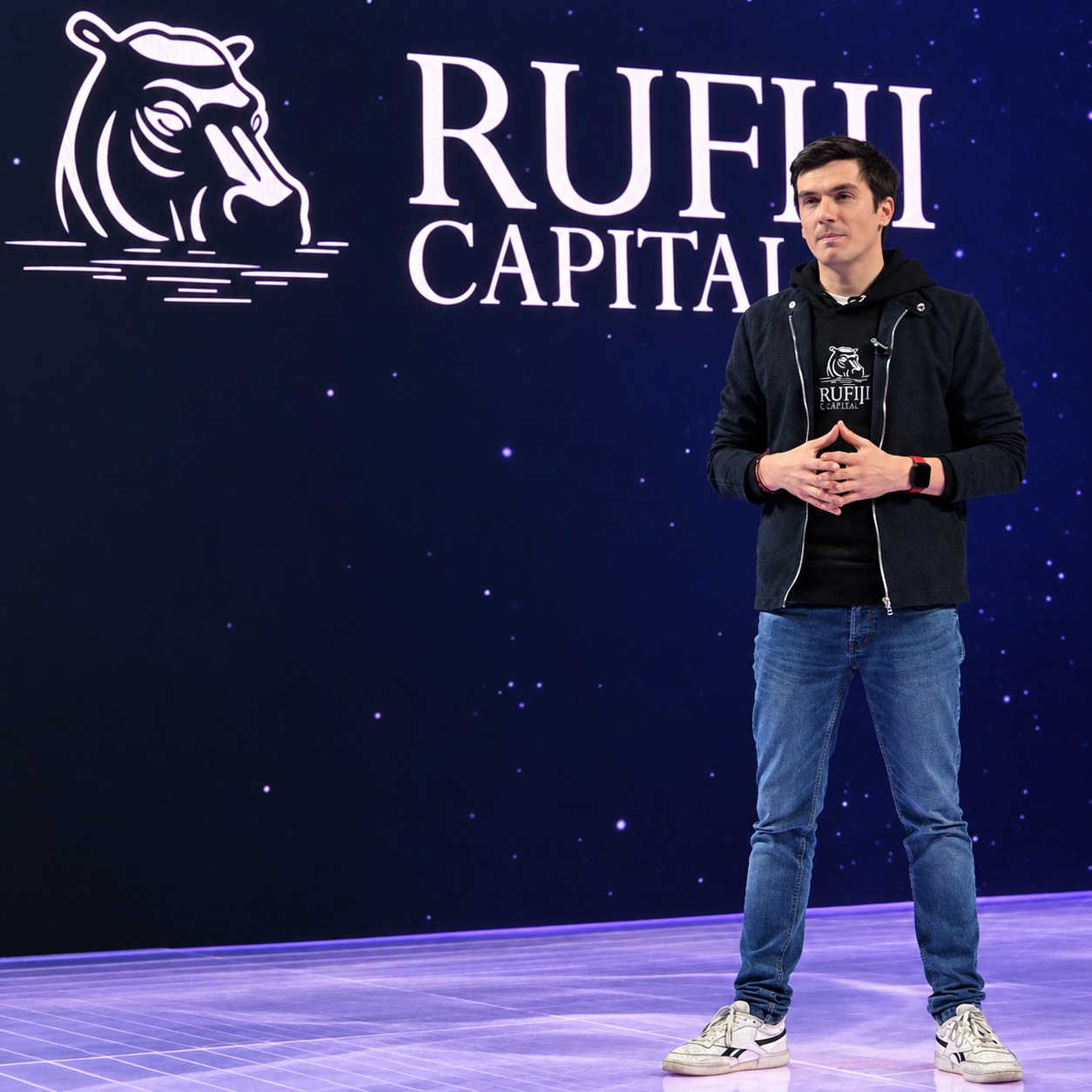 Matthias Vallet sur scène devant le logo RUFIJI Capital